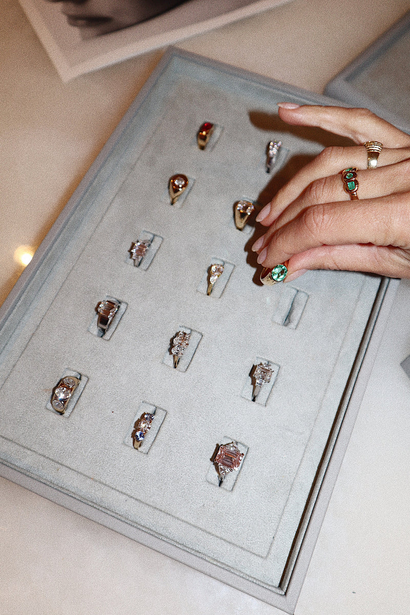 Sample of LINDELLI's signature diamond and gemstone engagement rings in signature blue display trays.